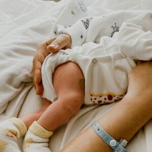 Tender moment captured between mother and newborn baby in a hospital setting.